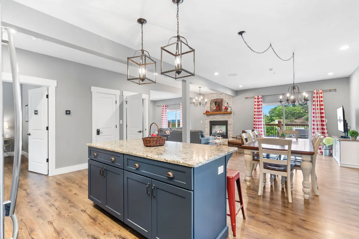 A cozy, combined kitchen and dining area featuring a large island, a welcoming dining table, and a fireplace. The room feels festive and intimate, ideal for sharing meals, stories, and special moments.