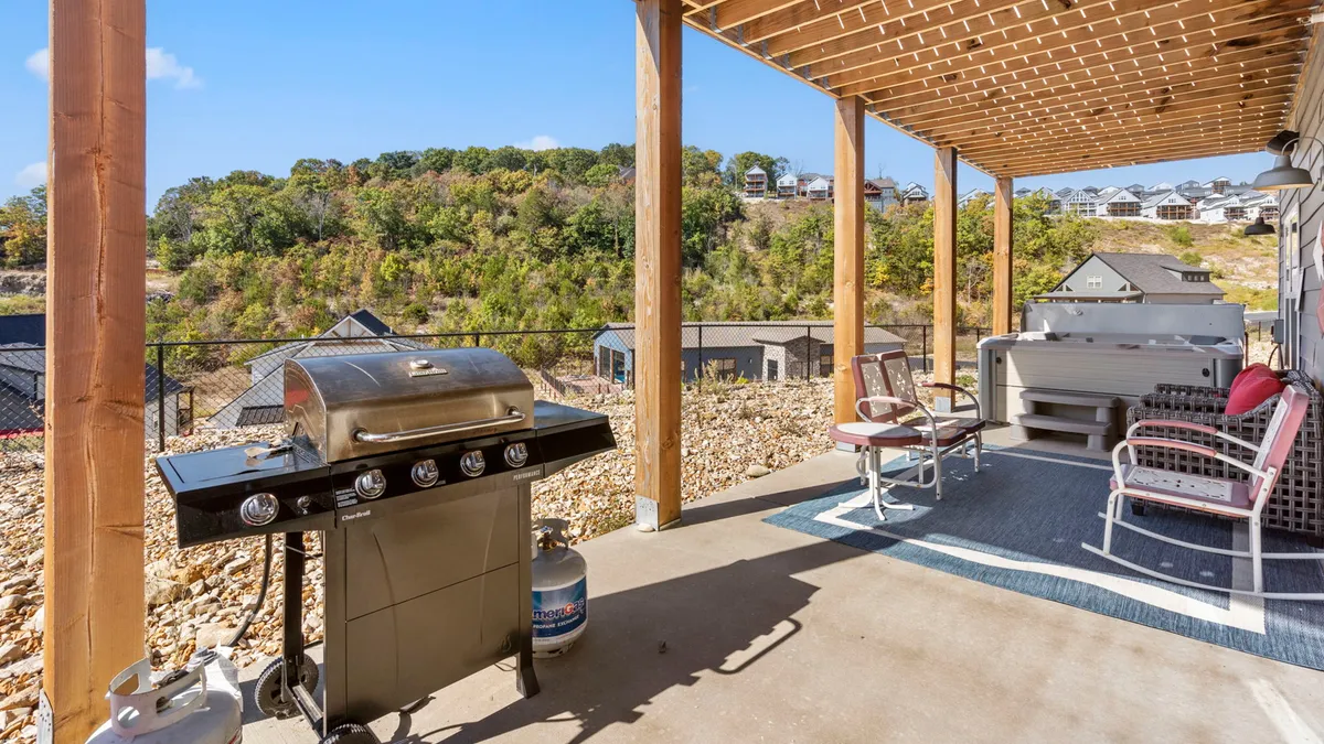 A spacious outdoor grill and seating area overlooking scenic hills, with plenty of room for guests to gather and celebrate. The setup suggests opportunities for outdoor dining, sunset dinners, and festive barbecues against a picturesque backdrop.